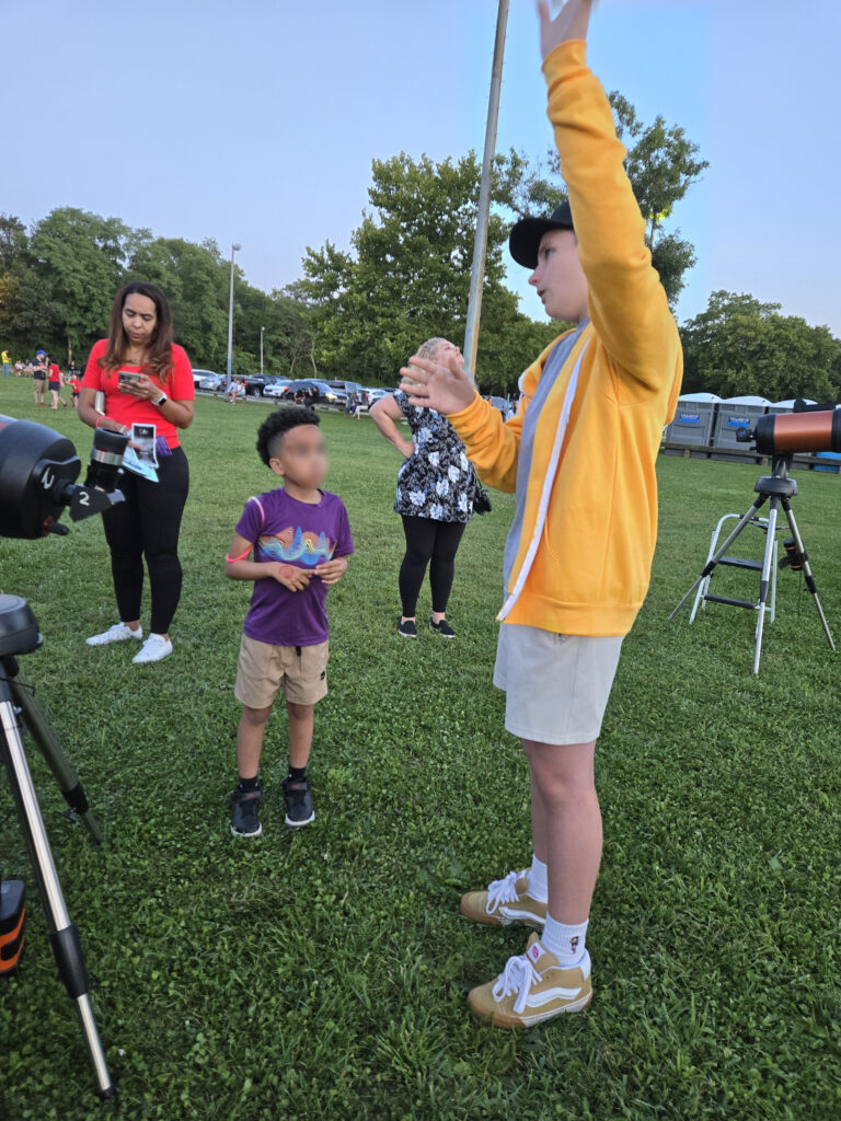 Young astronomer listens to AOSNY member describe the sky