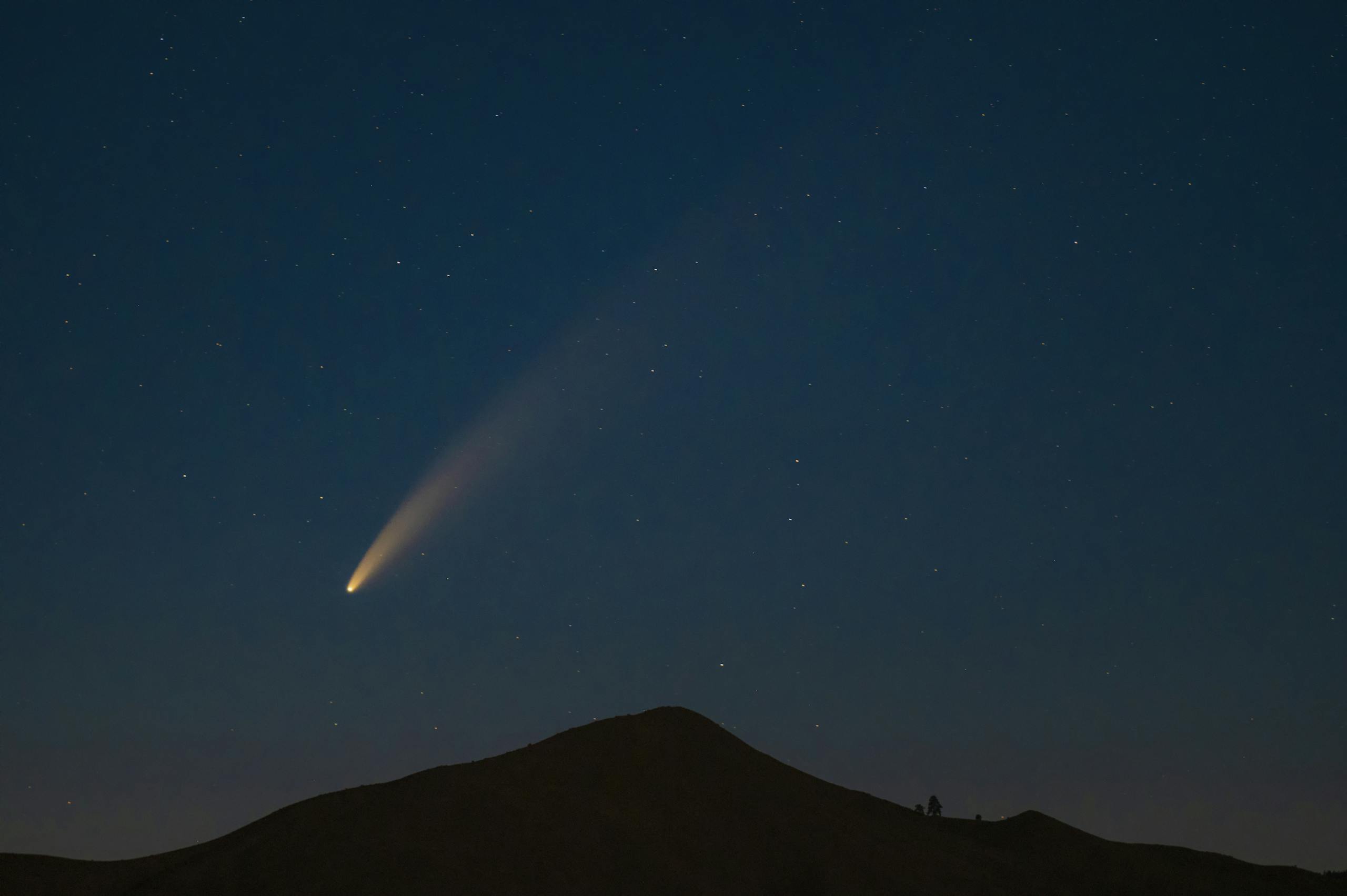 Night Shot of a Mountain and Comet in Sky